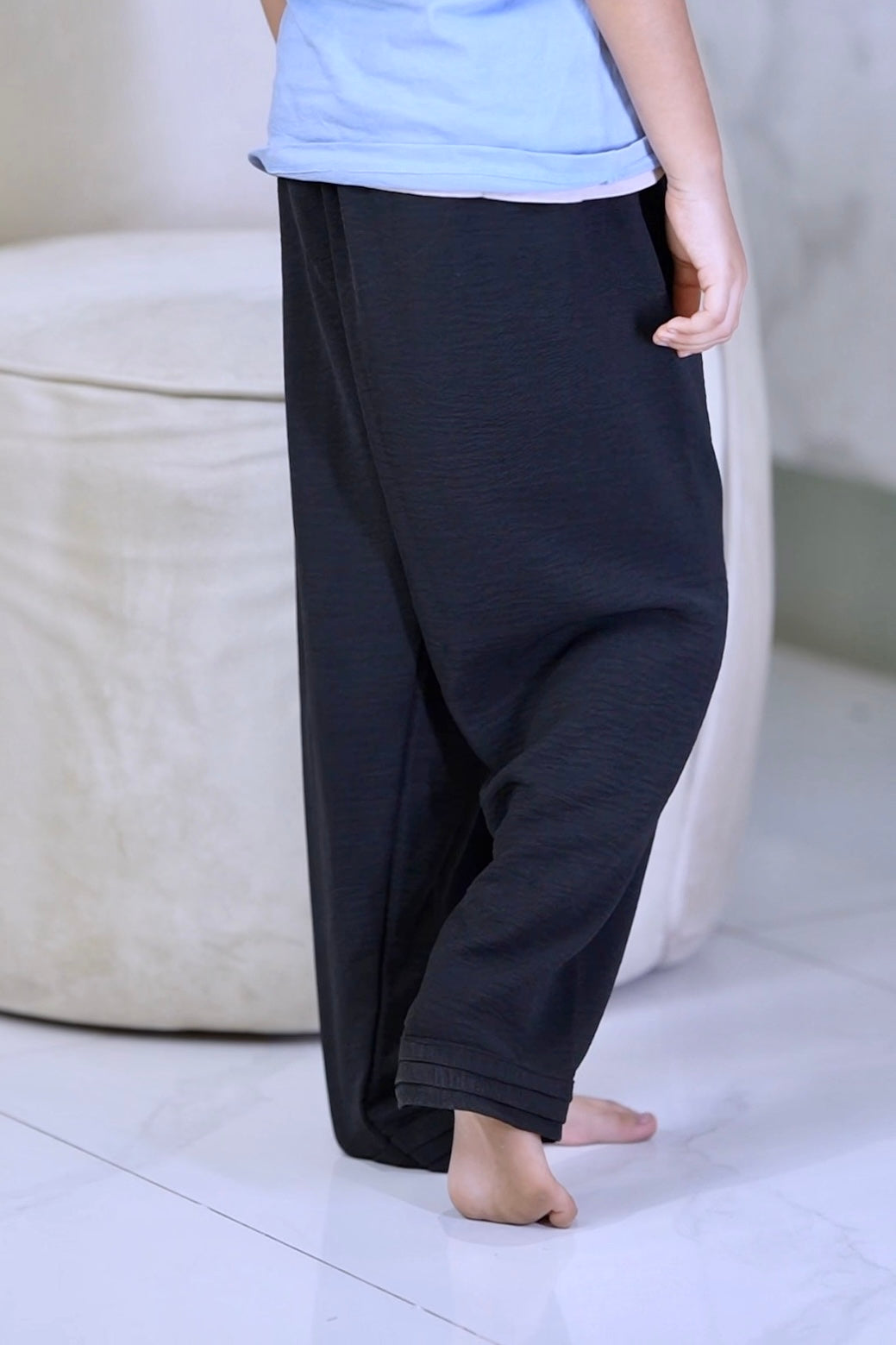 a baby girl is wearing modest collection's black summer friendly trousers