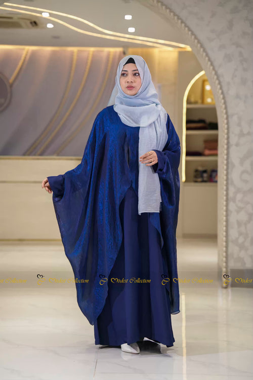 Woman wearing a blue batwing shrug abaya and light gray hijab in a Modest Collection outlet