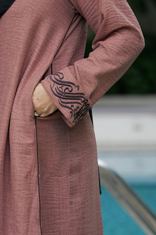 Close-up detail of Mocha Calligraphy Vest showing functional zipper-locked side pocket, front buttons, and embroidery.