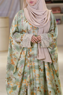 Woman wearing a floral dress with a beige hijab in an a modest collection store