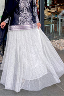 Close-up shot of white tulle fabric with black polka dot pattern and smooth nylon interior lining.
