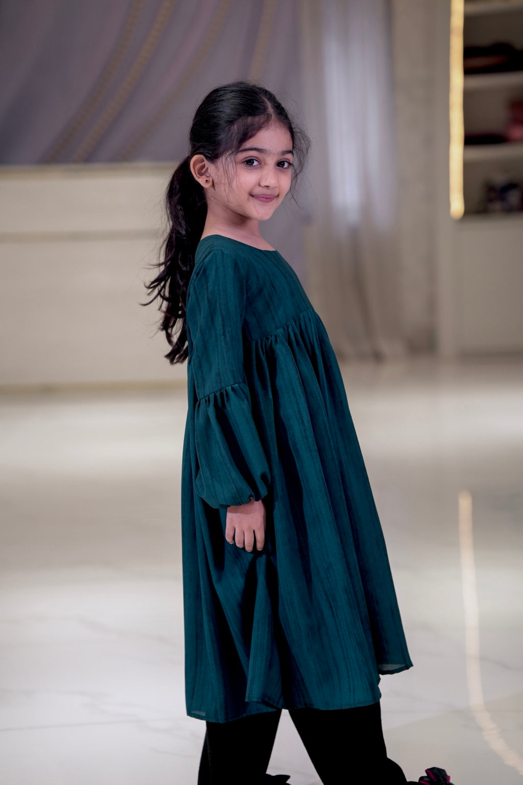 Close-up of the Little Veila Top's lantern sleeve design and elegant round neckline.