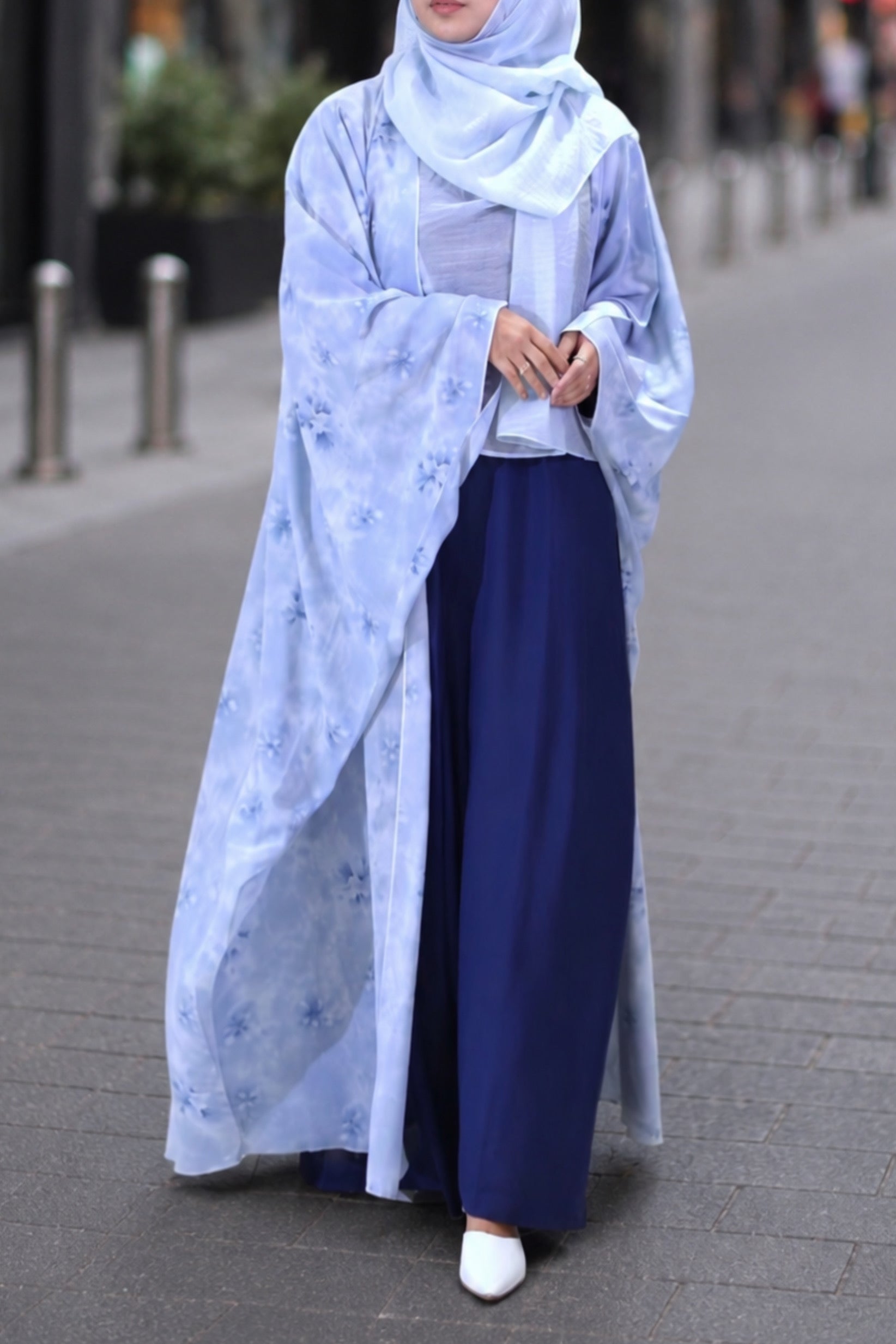 Model wearing the Ocean Shrug, an open-front floral georgette layer in blue shades, perfect for office formal wear or holiday outings