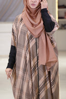 Woman wearing a patterned hijab and safiya maternity kaftan abaya in a neutral setting