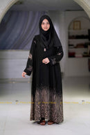 Woman wearing Sidra black abaya with tan floral embroidery, suitable for Hajj and summer weather