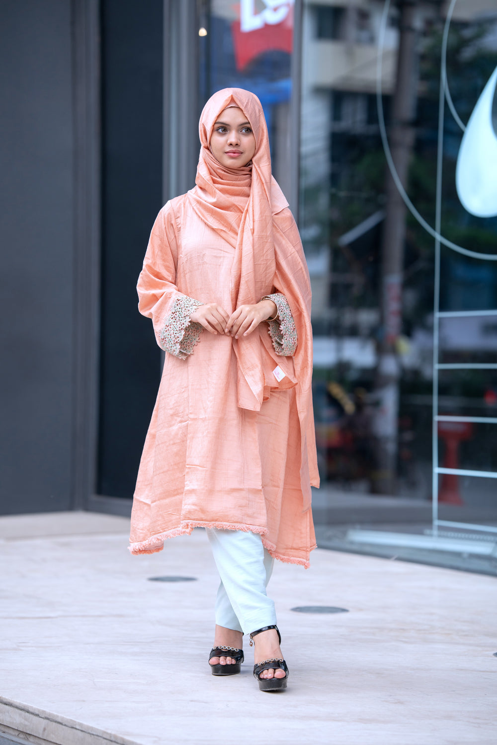Front view of model wearing Sunshine Tunic in peach cotton silk blend with matching trousers and hijab