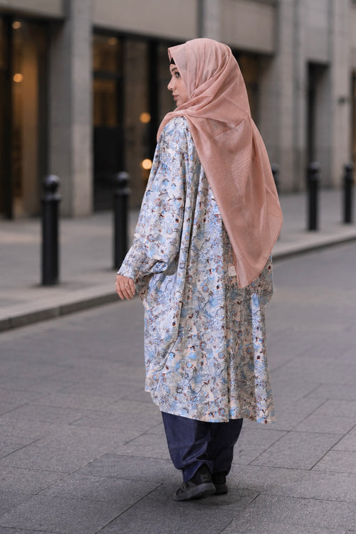 A woman wearing the comfortable, free-size Tanaka Top in Azure, showcasing its flattering drape and modest 42-inch length.