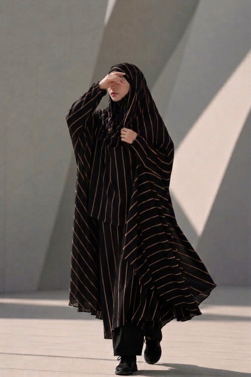 Full-length side profile of a woman modeling the Urban Stripe Khimar in black and gold georgette fabric.