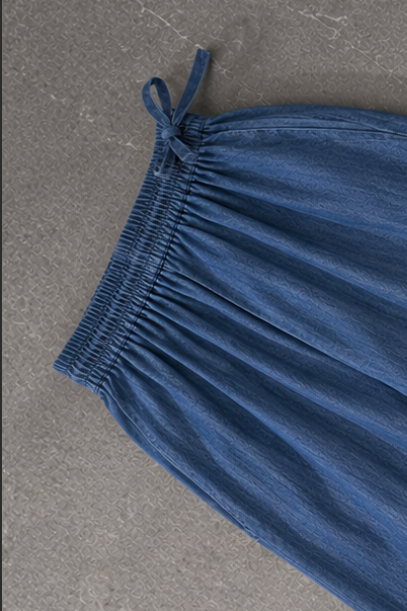 Blue denim trousers on a gray surface
